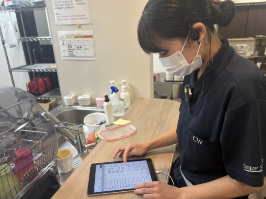 タブレットで記録を入力する先輩職員